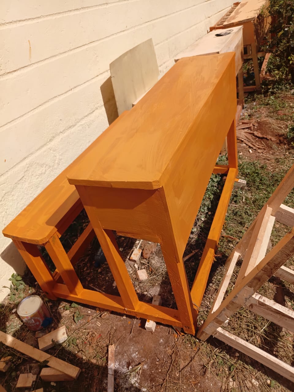 Newly varnished wooden desk and bench set drying outside