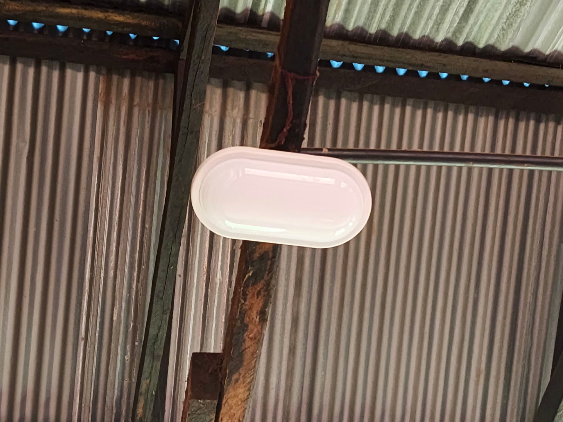 Newly installed oval ceiling light under the corrugated roof