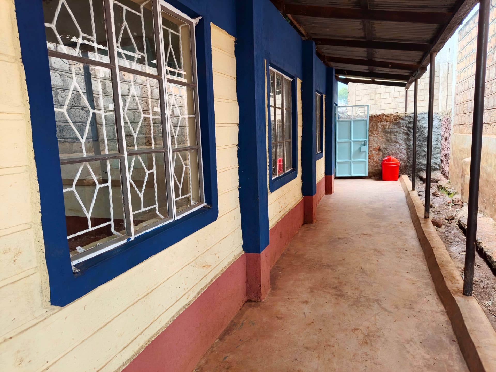 Refurbished classroom corridor with blue pillars and window grilles