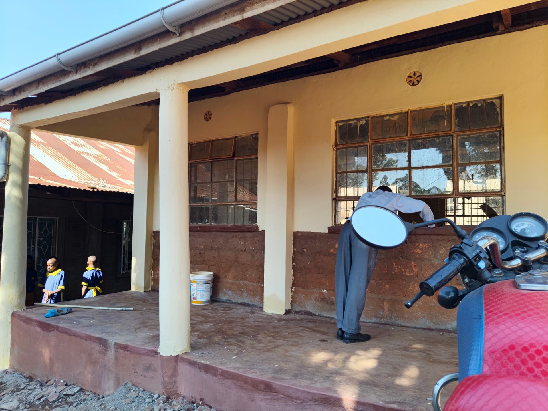 Workman preparing classroom walls for painting