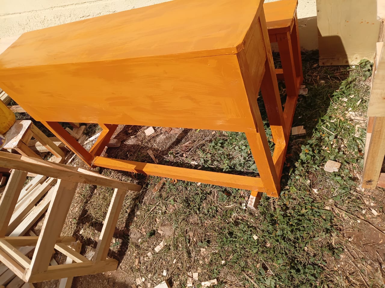 Pair of completed desks stacked beside the carpentry workshop