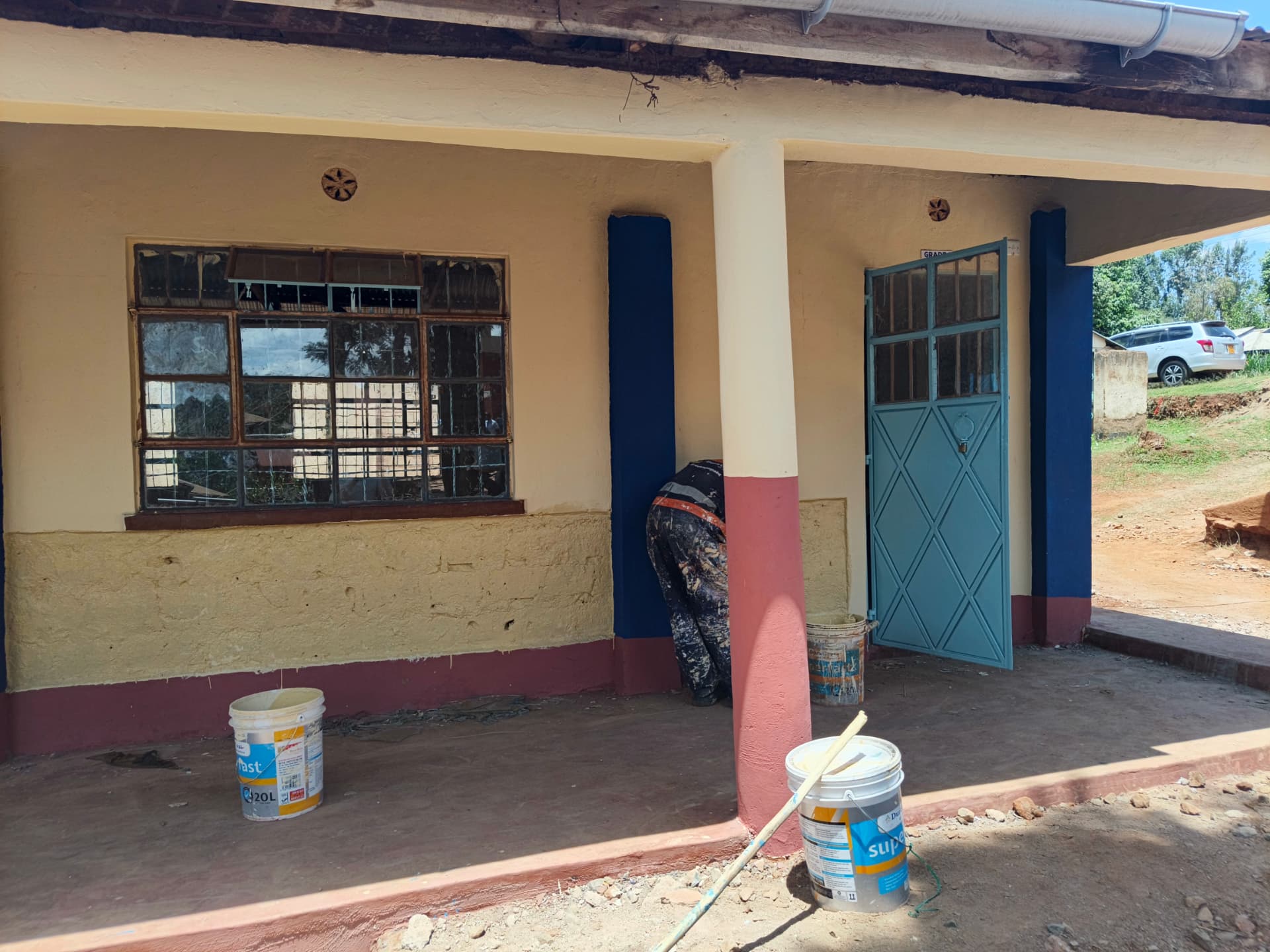 Repainted classroom entrance with new blue door and maroon plinth