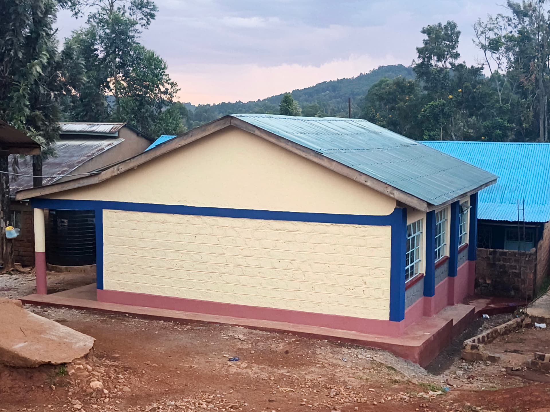 Side view of the finished classroom block with new roof and painted gable