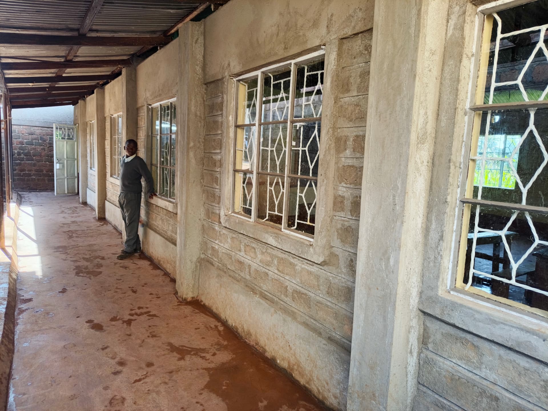 Learner standing in a refurbished classroom corridor