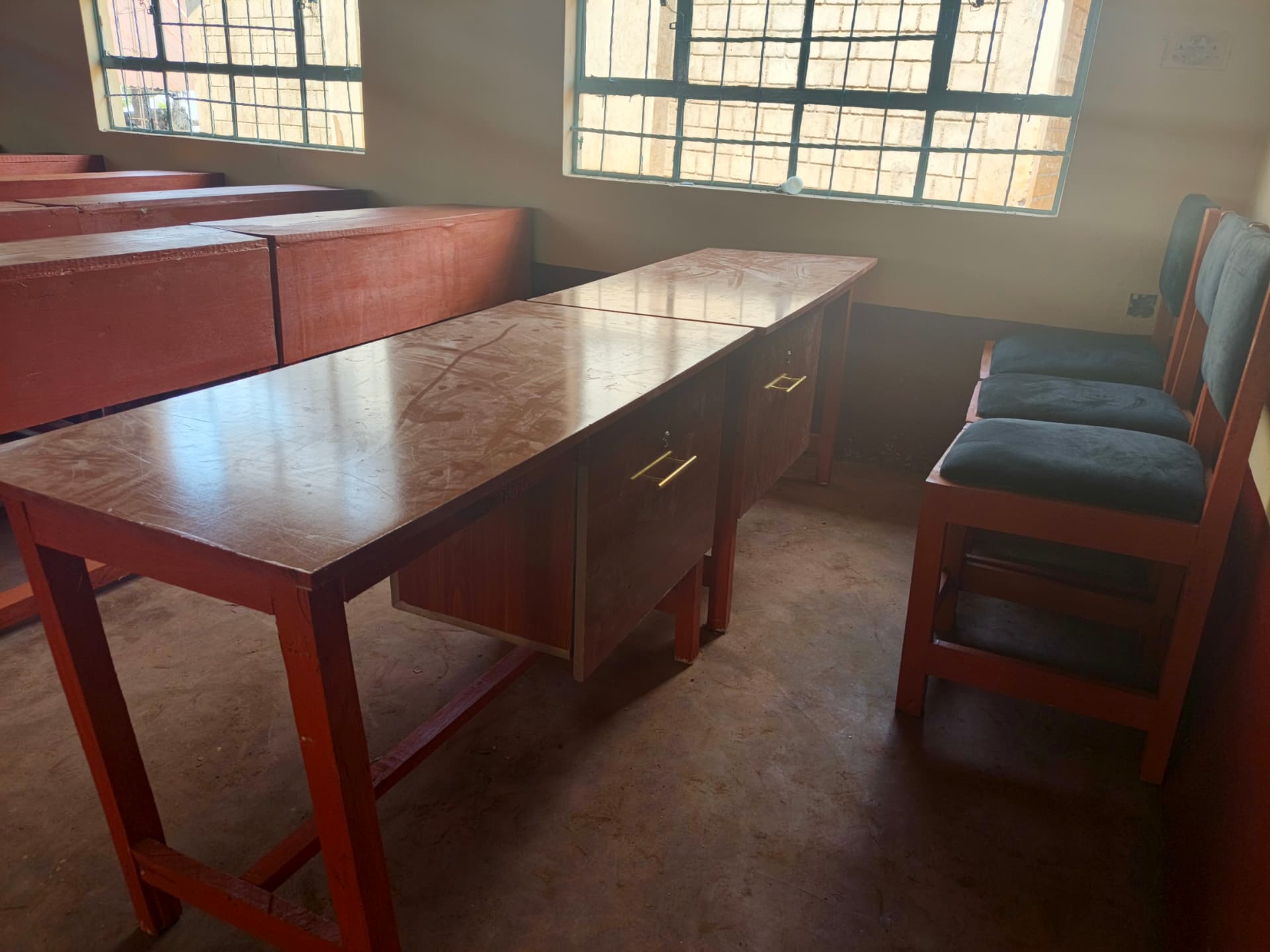 Classroom filled with rows of newly varnished reddish-brown learner desks