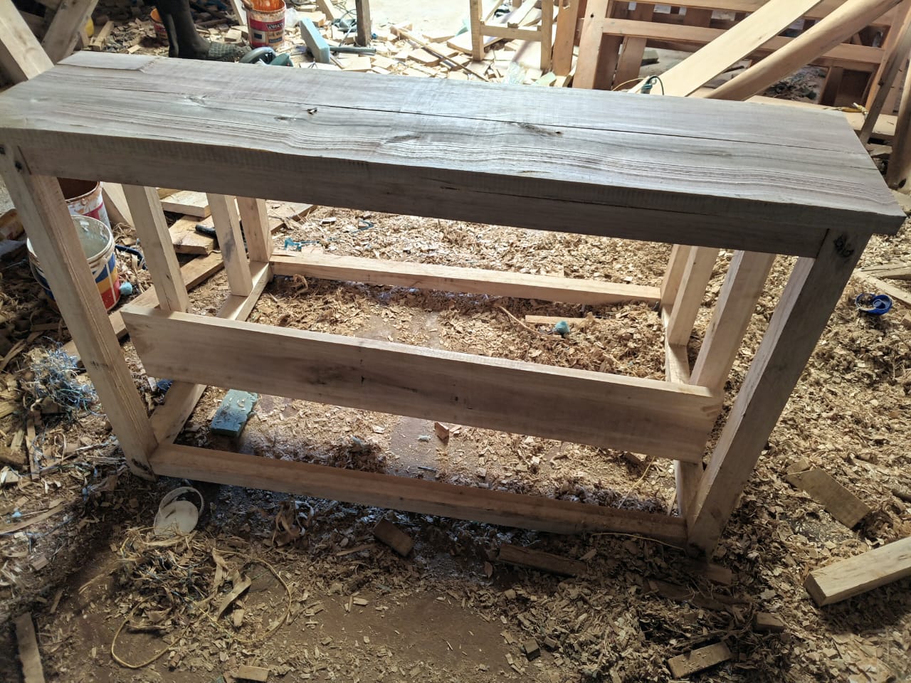 Completed desk frame standing in the carpentry workshop