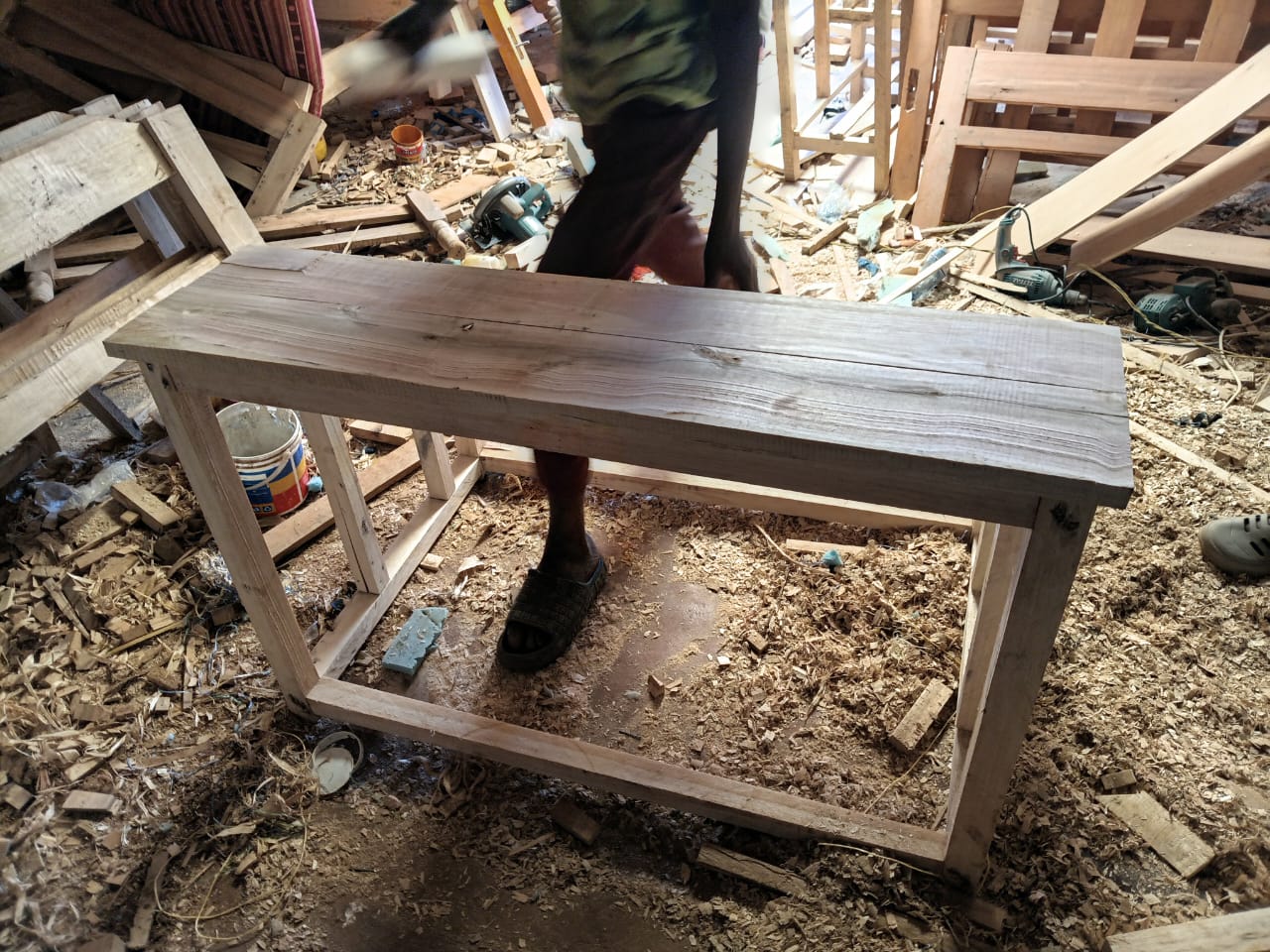 Carpenter assembling a new wooden desk in the workshop