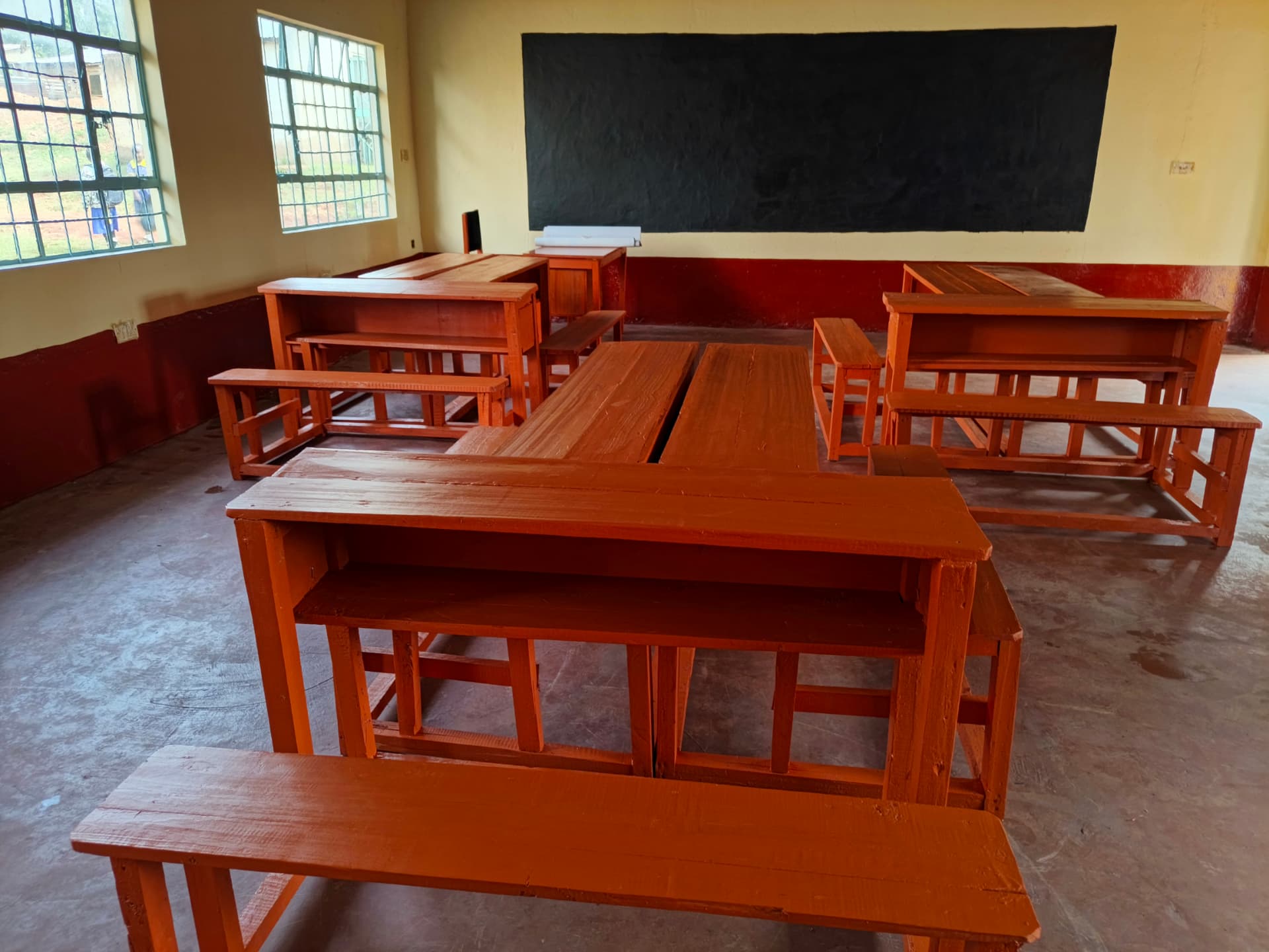 Classroom with new wooden desks, benches and blackboard